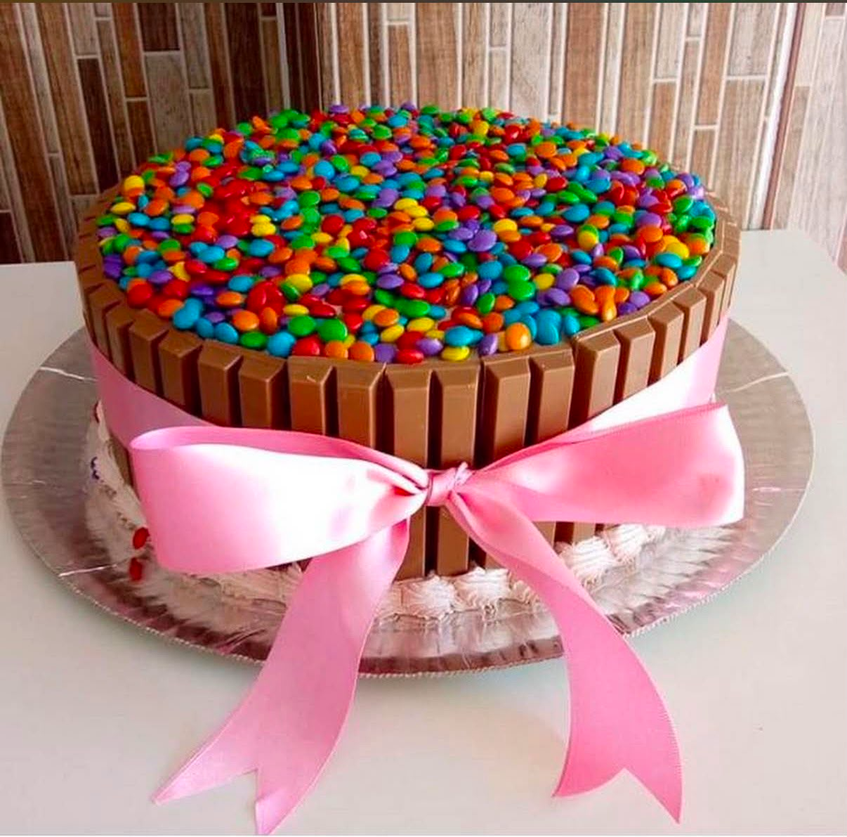 Bolo decorado com chocolates e confetes coloridos